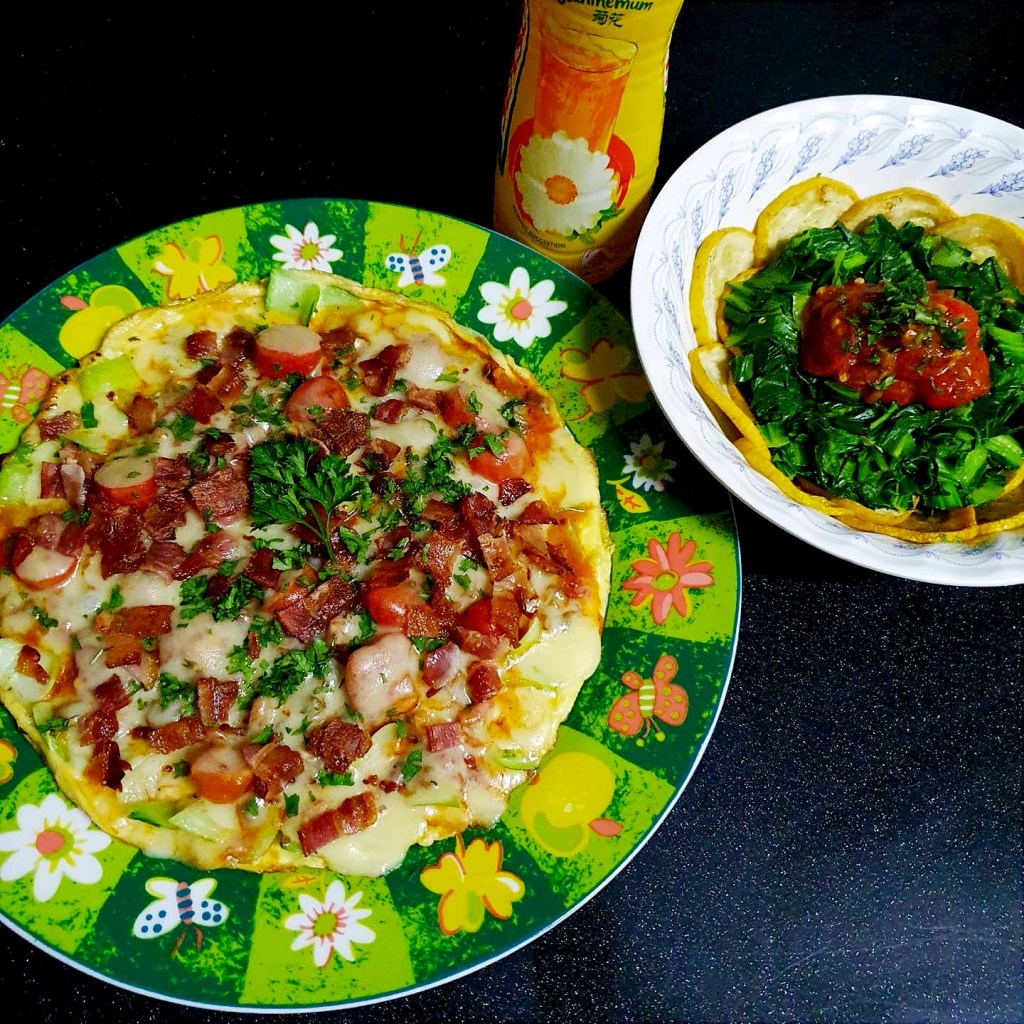Omelette pizza with bacon and herbs on a floral plate, served with veggie egg bowl.